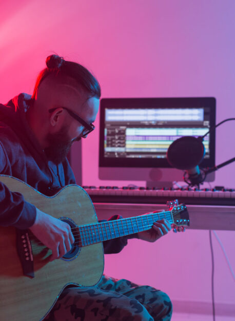 Create music and a recording studio concept - Bearded funny man guitarist recording electric guitar track in home studio Create music and a recording studio concept - Bearded man guitarist recording electric guitar track in home studio.